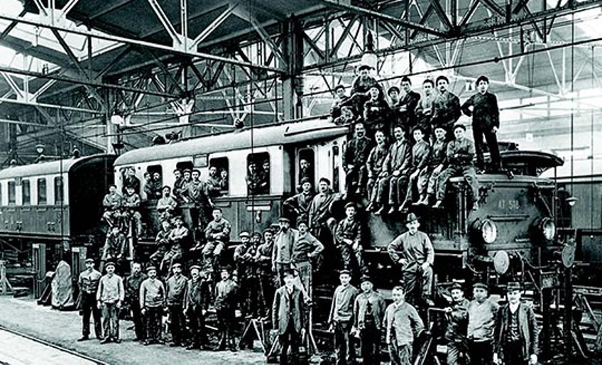 Unternehmensgeschichte - Eisenbahner sitzen auf Zug